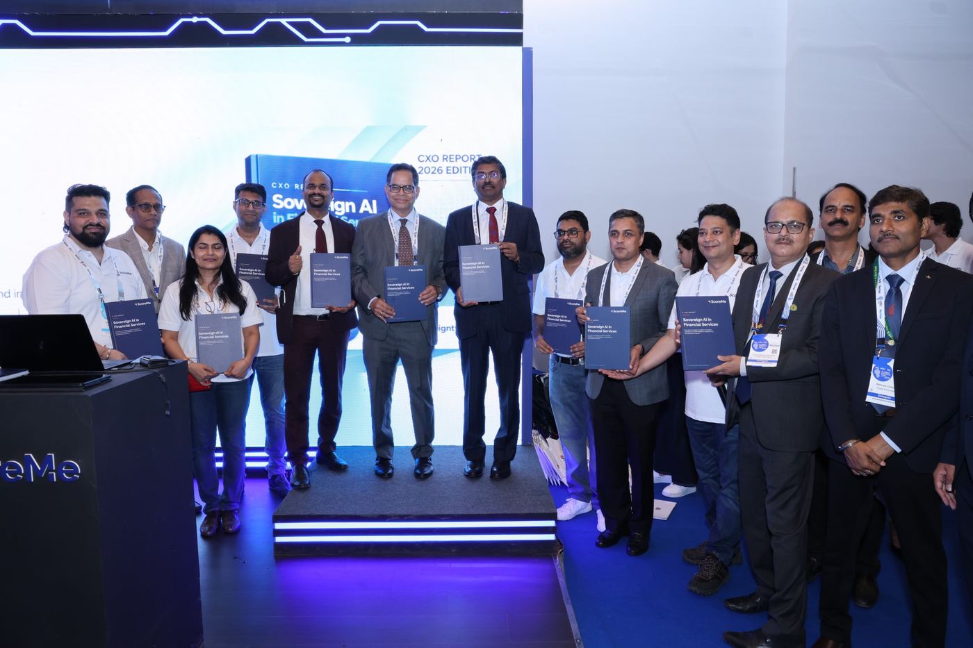 Banking and ScoreMe leaders on stage holding the Sovereign AI report, with the CXO Report 2026 edition on the screen behind them.