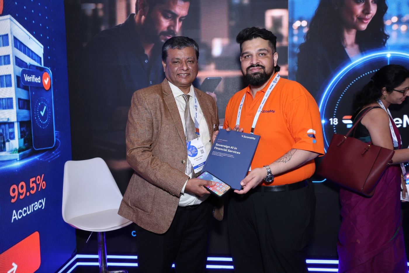 A senior delegate holding a copy of the report at the ScoreMe stand.