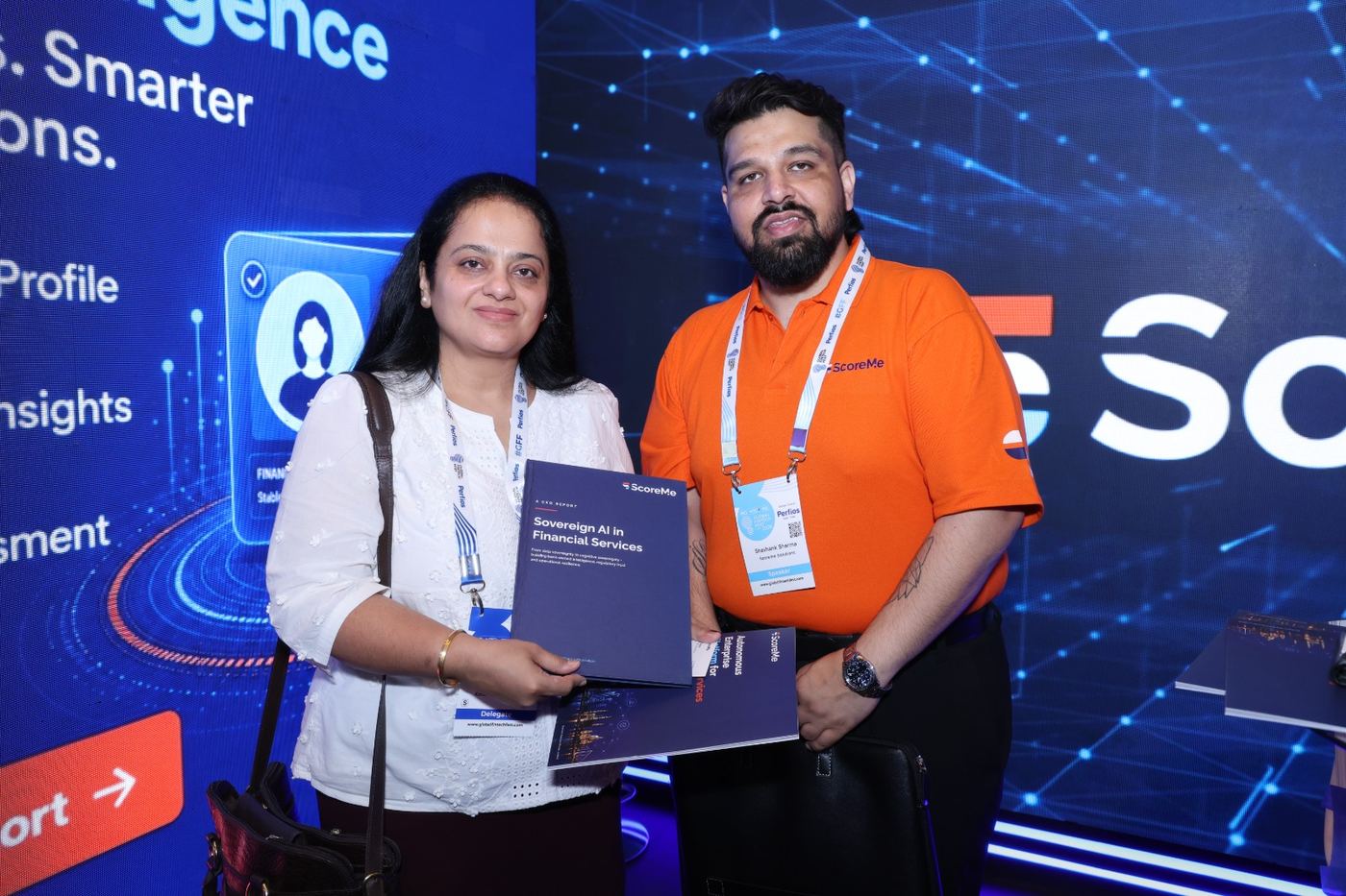 A delegate holding the report beside a ScoreMe representative at the stand.